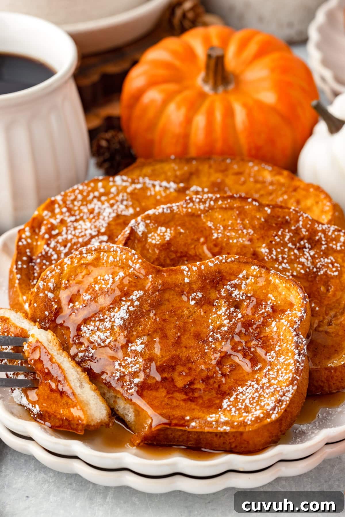 Three slices of pumpkin French toast with a slice cut off with a fork.