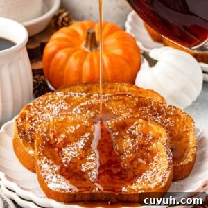 Pumpkin Spice French Toast Recipe: Crispy Cinnamon Pumpkin Toast 8 Three slices of pumpkin French toast dusted with powdered sugar are on a white plate.