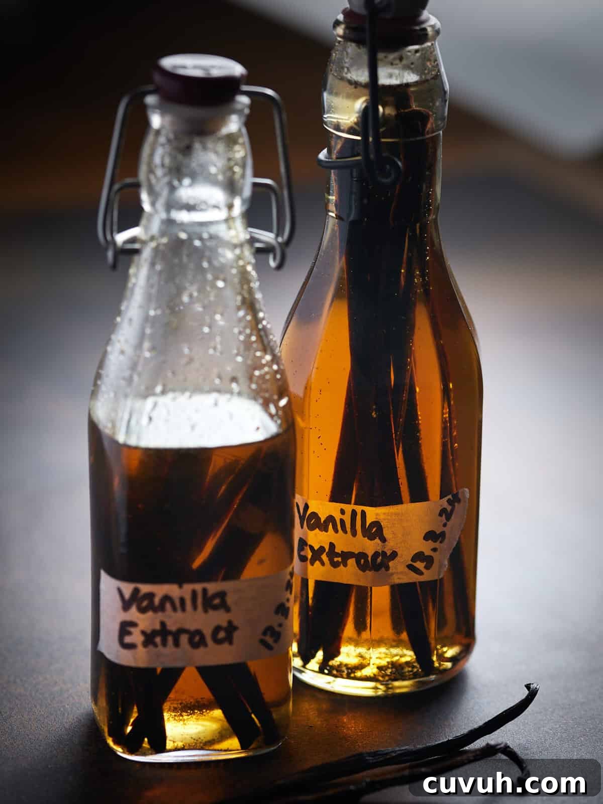 Photo of two bottles of vanilla extract, with one half used while the other one is full behind.