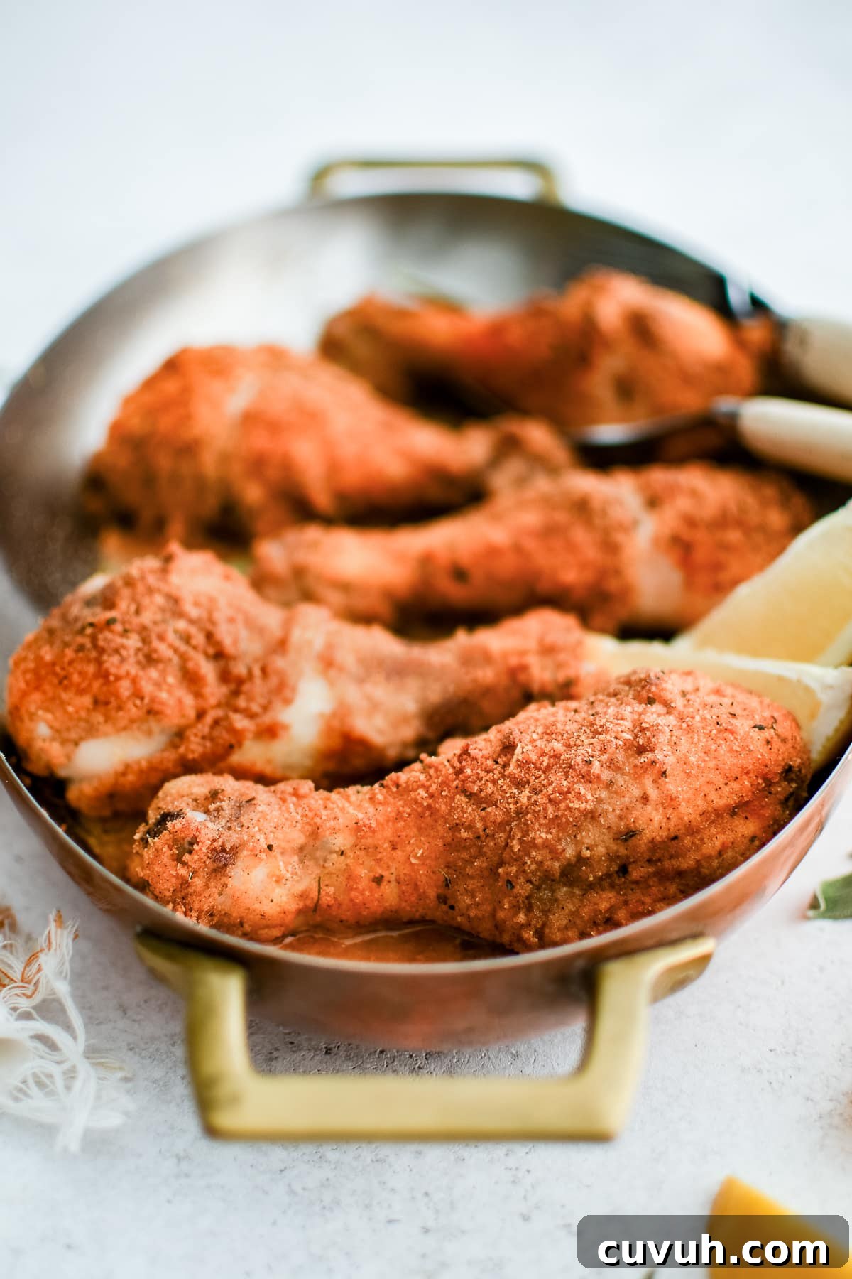 Crispy Shake-and-Bake Chicken Recipe for Perfect Weeknight Meals 11 Oval-shaped baking dish filled with five golden, crispy baked chicken drumsticks coated in shake and bake seasoning.