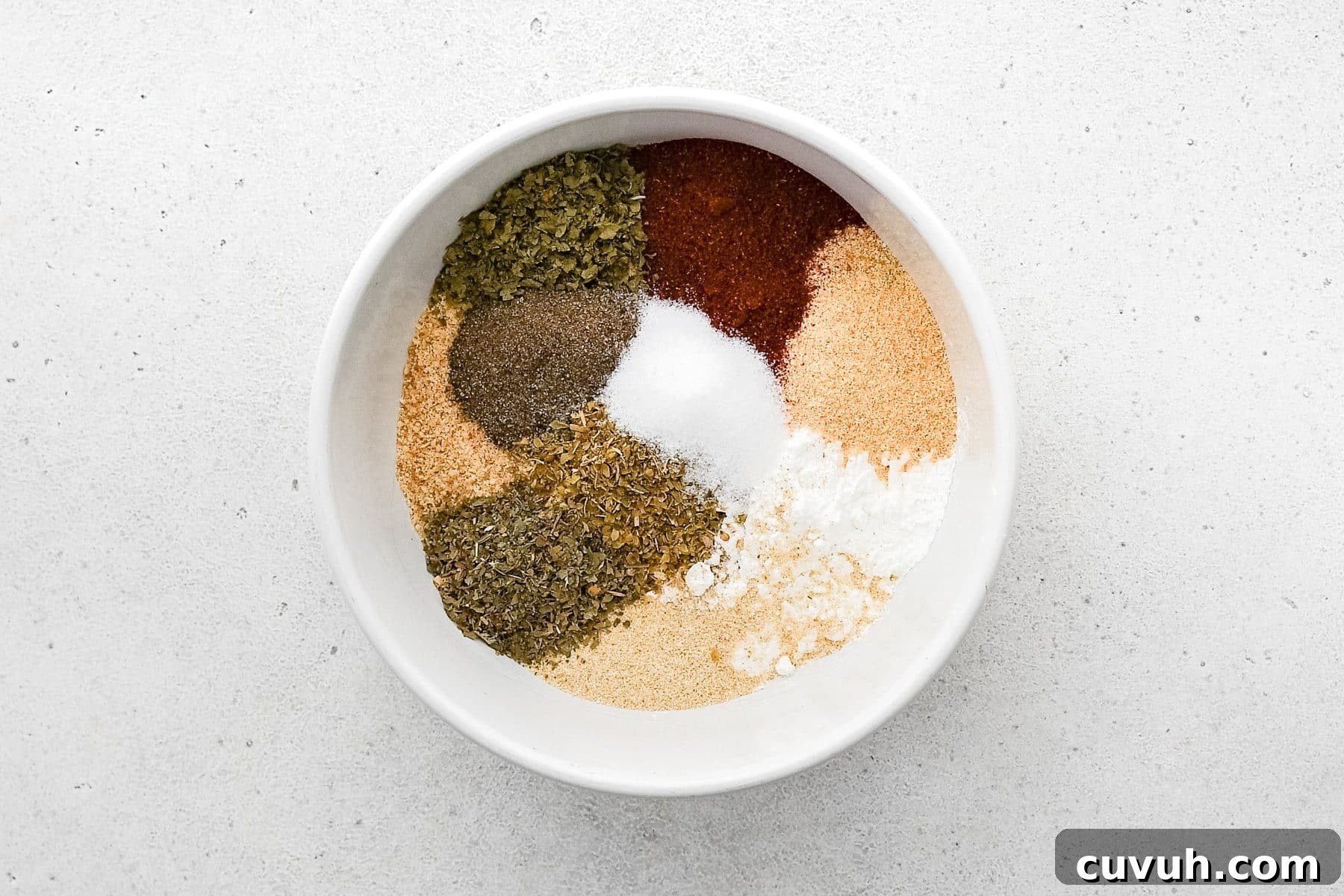 Crispy Shake-and-Bake Chicken Recipe for Perfect Weeknight Meals 5 White bowl filled with breadcrumbs, cornstarch, and various seasoning and spices before being mixed together.