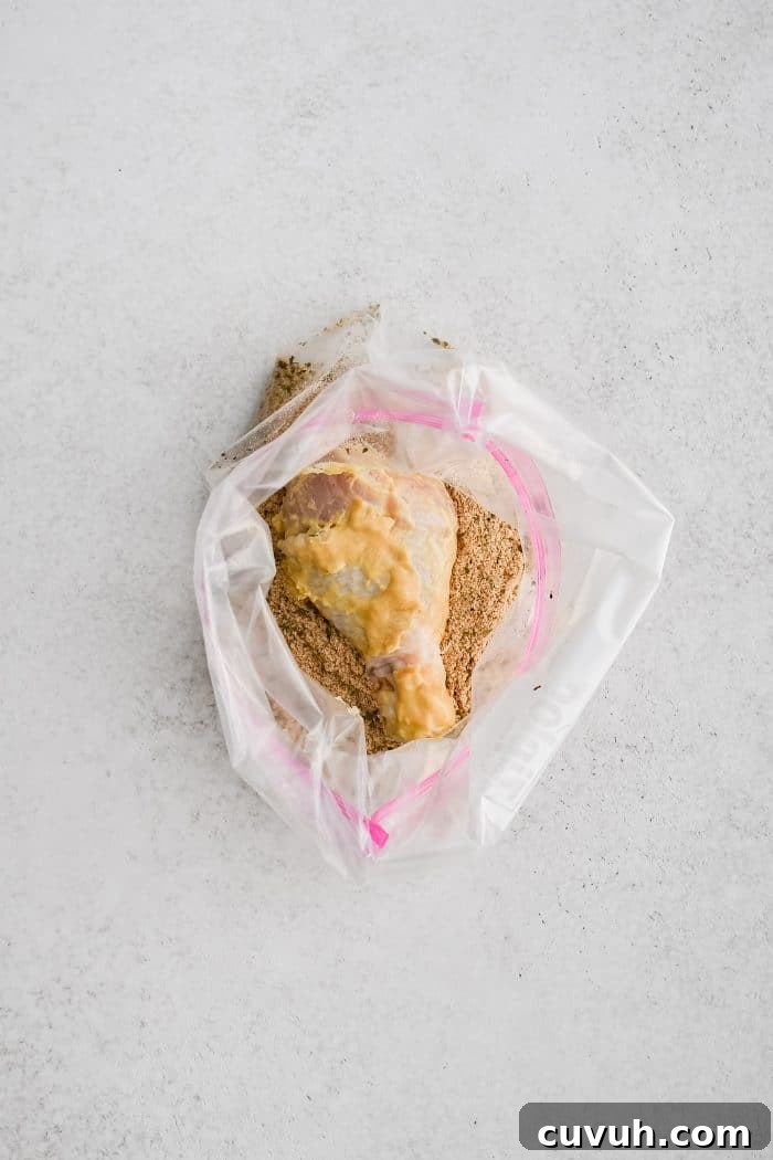 Crispy Shake-and-Bake Chicken Recipe for Perfect Weeknight Meals 8 Ziplock bag filled with raw chicken drumsticks coated in melted butter and Dijon mustard and homemade shake and bake seasoning.
