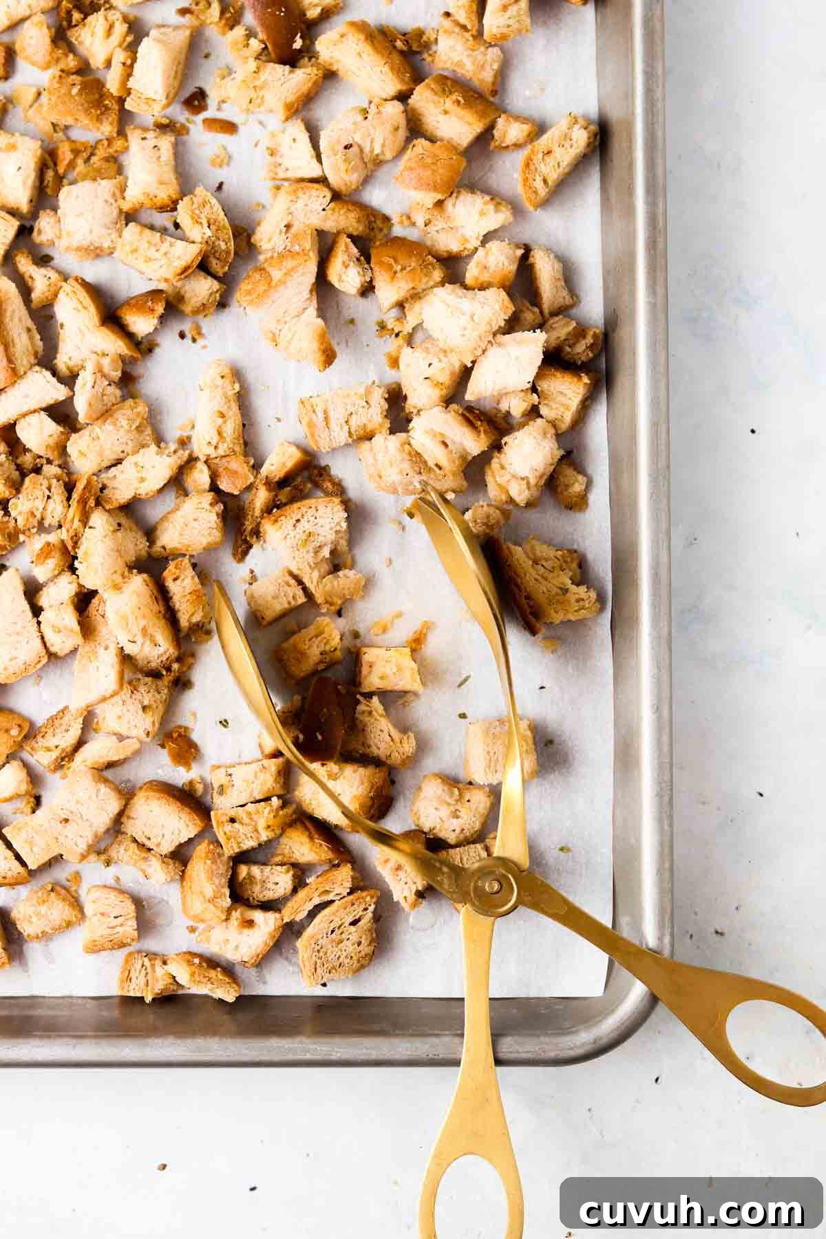 Baked gluten free croutons with tons on a baking sheet.