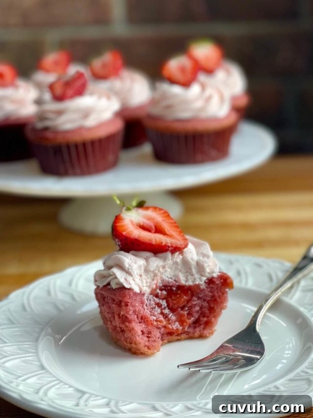 Bakery-Style Strawberry Buttercream Frosting Recipe 4 strawberry cupcakes with fresh strawberry cupcake filling and strawberry frosting on top.
