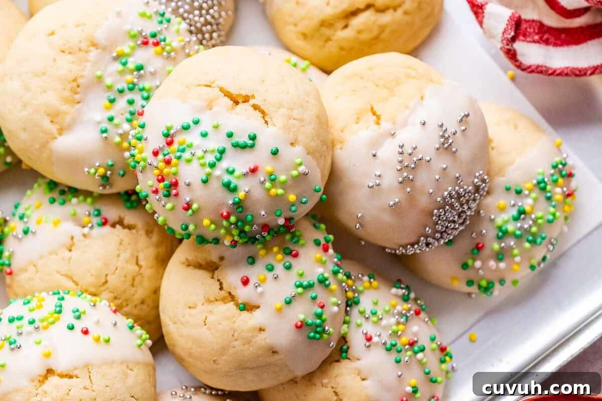 Italian Christmas Cookies with sprinkles next to a red and white striped napkin.