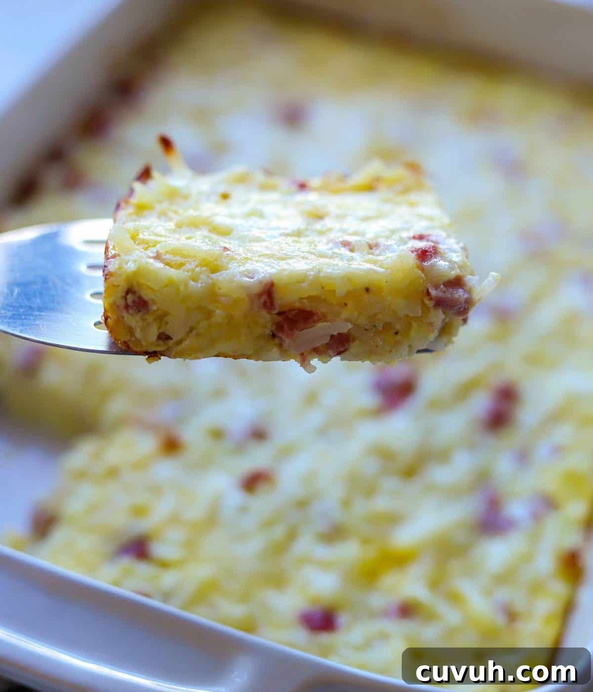 Spatula holding up slice of breakfast casserole.