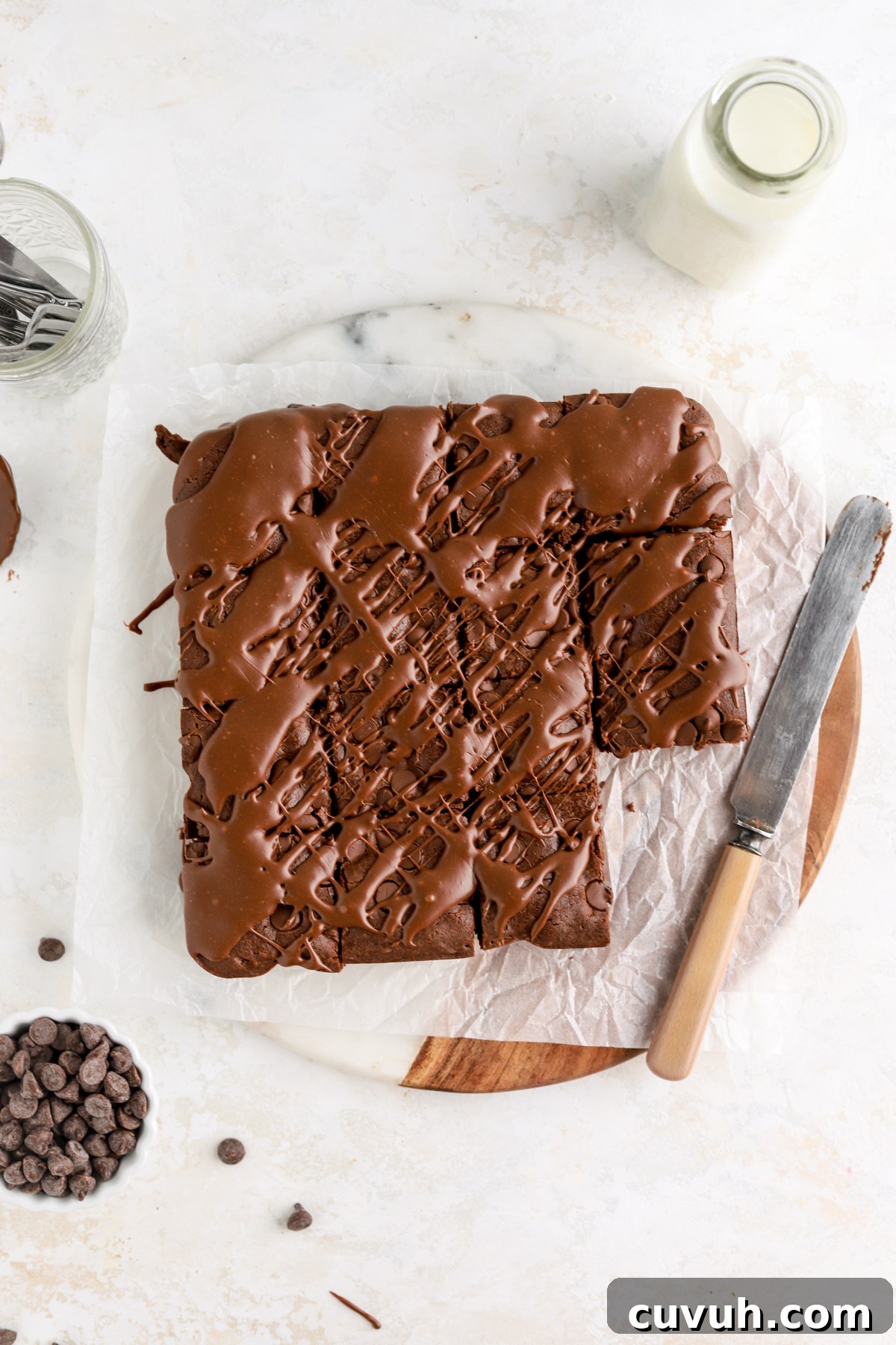 Brownies drizzled with chocolate and a bowl of chocolate chips