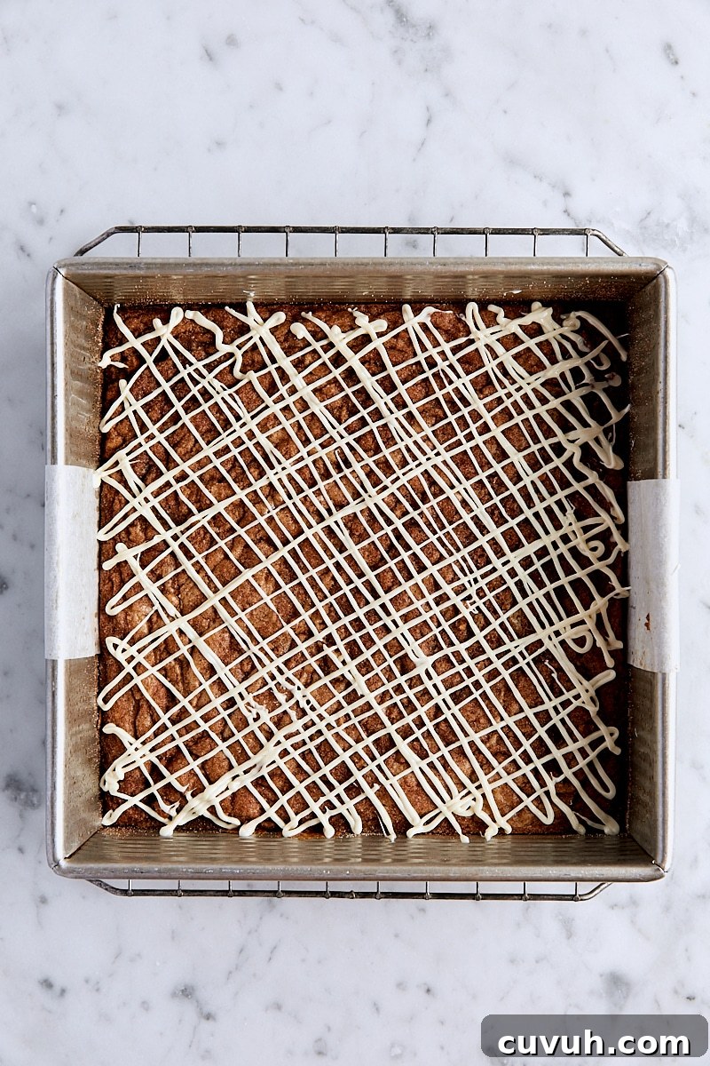 Blondies drizzle with white chocolate in parchment-lined square pan