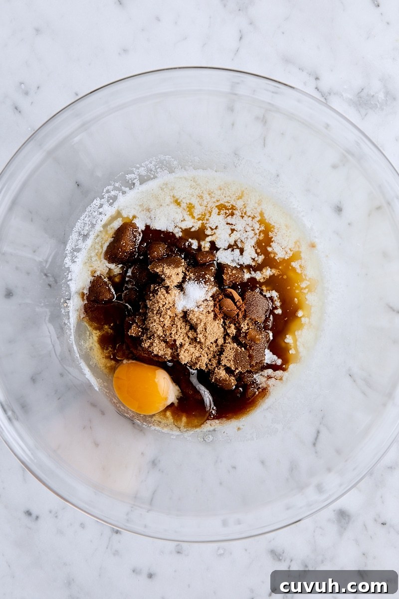 Melted butter, brown sugar, egg, vanilla, cinnamon, and salt in glass bowl