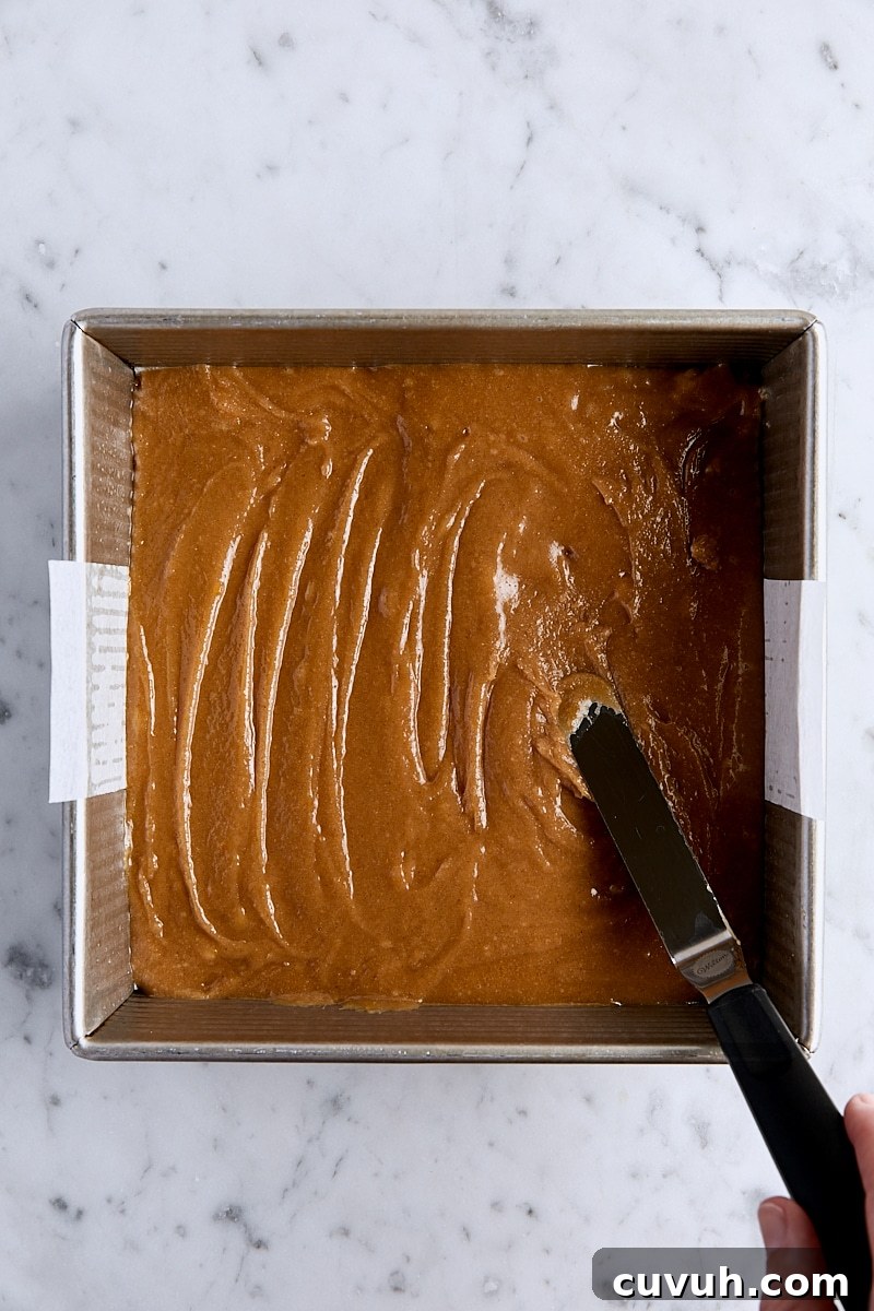 Snickerdoodle blondie batter in parchment-lined square pan