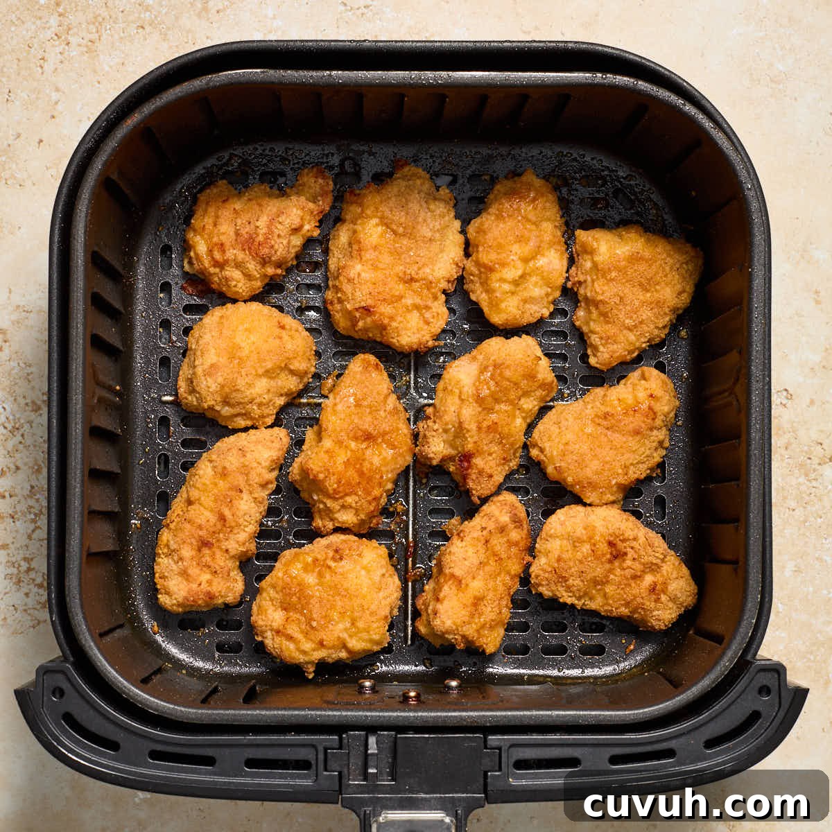 Air fried boneless wings in an air fryer basket.