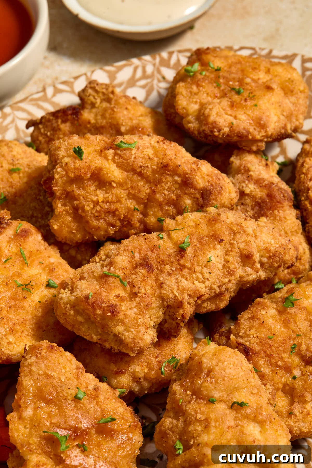 Side view of boneless wings on a platter and garnished with chopped parsley.