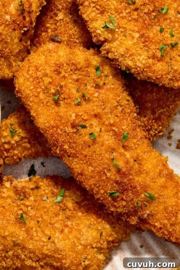 Close up view of air fryer cornflake chicken strips on a plate.