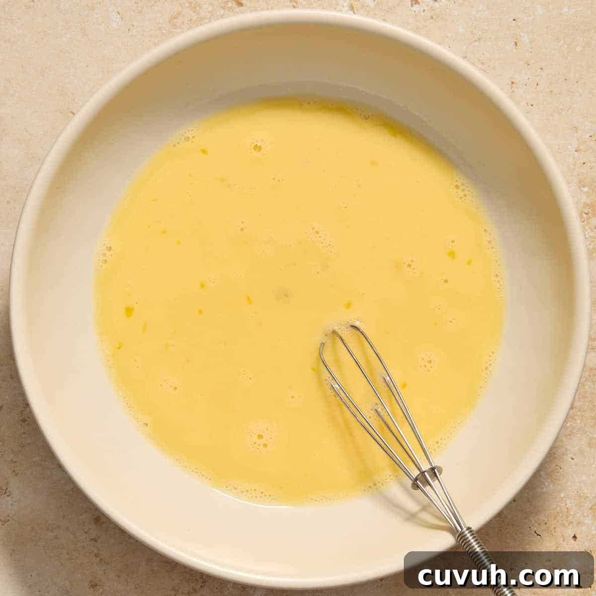 Eggs and milk whisked together in a shallow bowl.