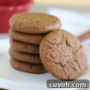 Stack of five ginger snap cookies on a white plate.
