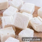 Large marshmallows laid out on a cutting board.