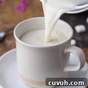 Hot milk with vanilla being poured into a mug.
