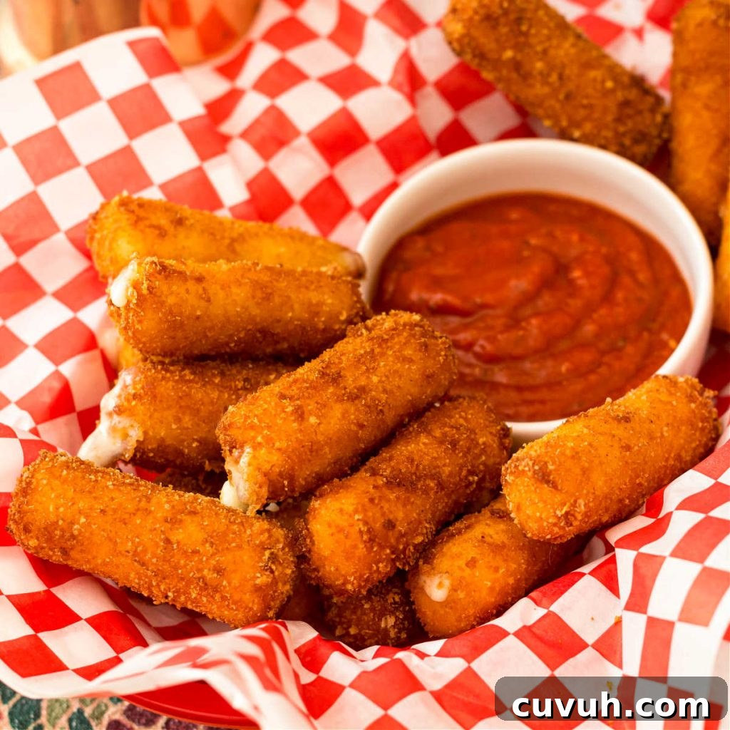 Basket with fried mozzarella sticks and marinara sauce for dipping.