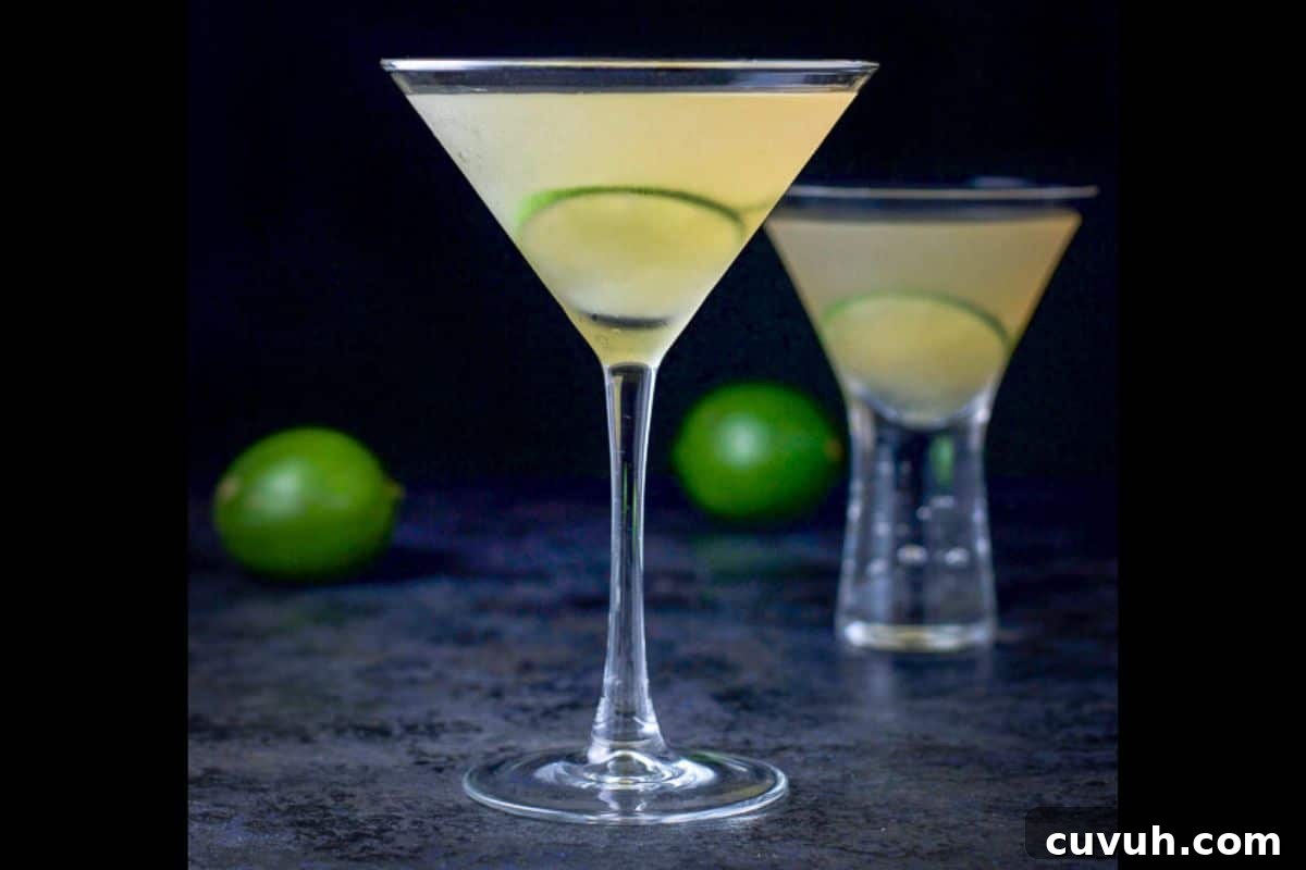 two martini glasses filled with the daiquiri with limes as garnish