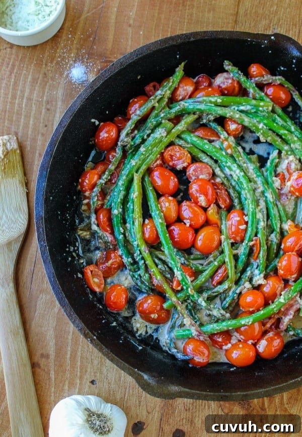 asparagus and cherry tomatoes in a cast iron skillet.
