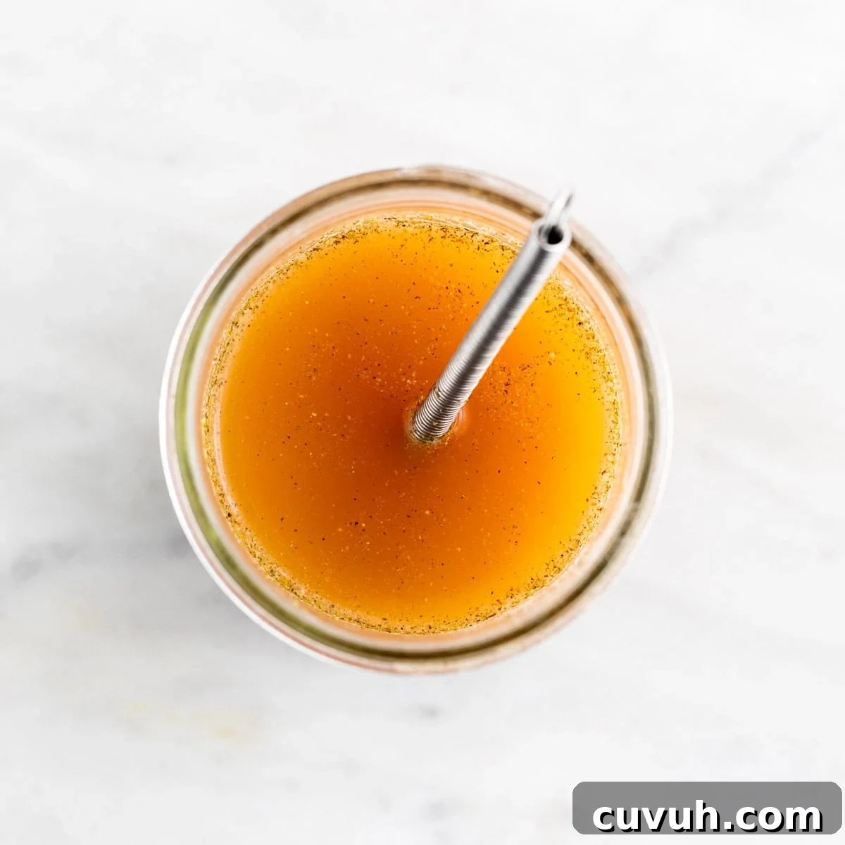 Vegan beef broth ingredients mixed in a jar with a small whisk.